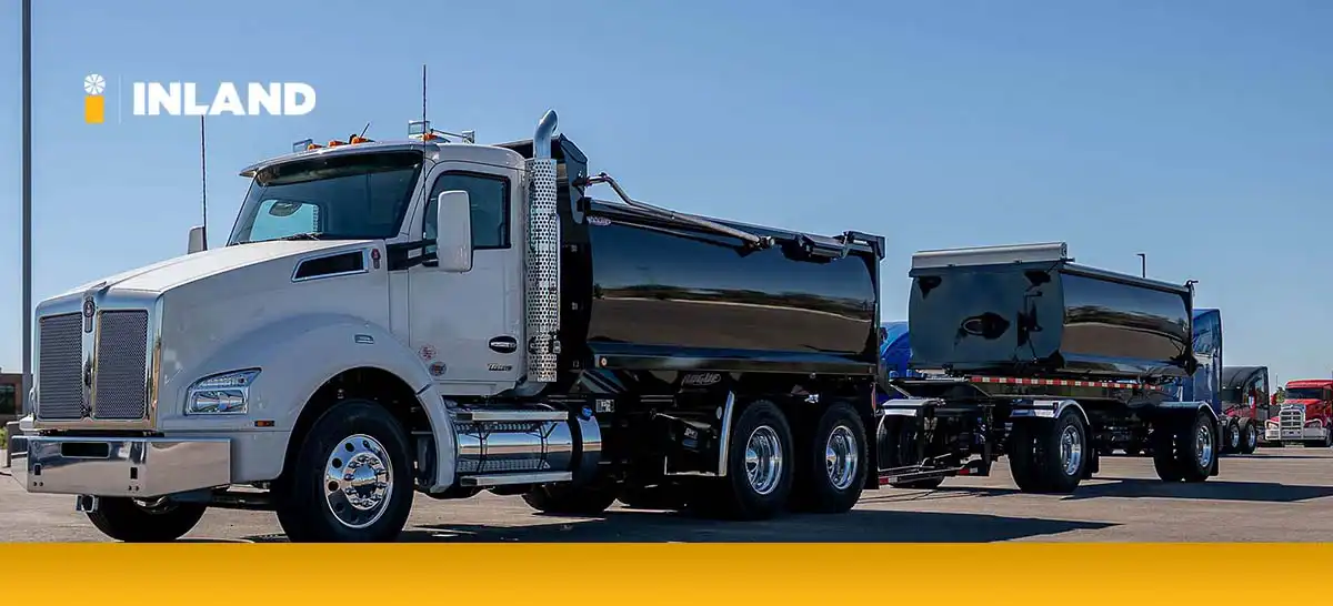 White Kenworth T880 dump truck with a pup trailer, illustrating heavy-duty types of trucks used in construction logistics and material transport.