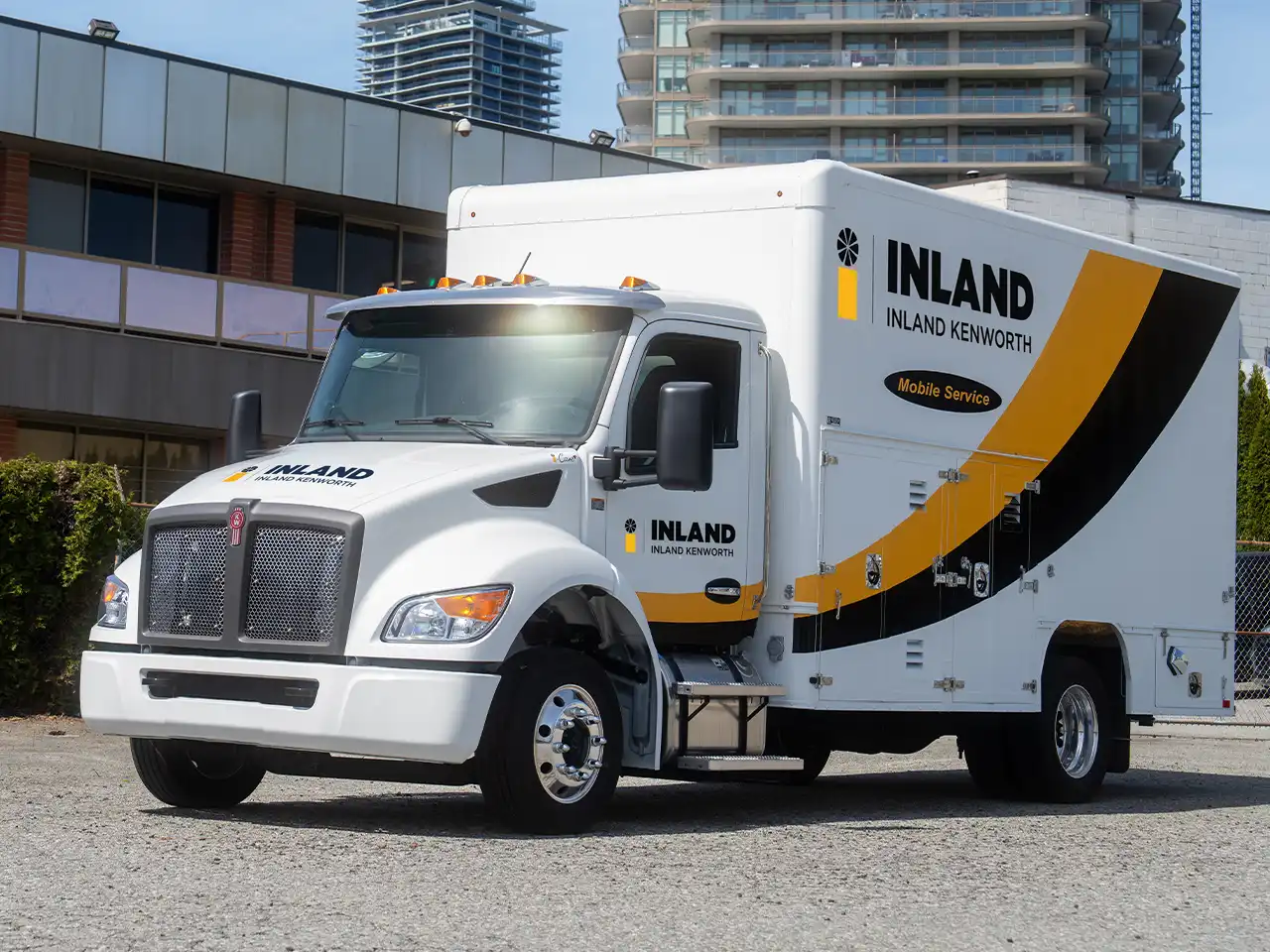 An Inland Kenworth mobile service truck parked by a road.