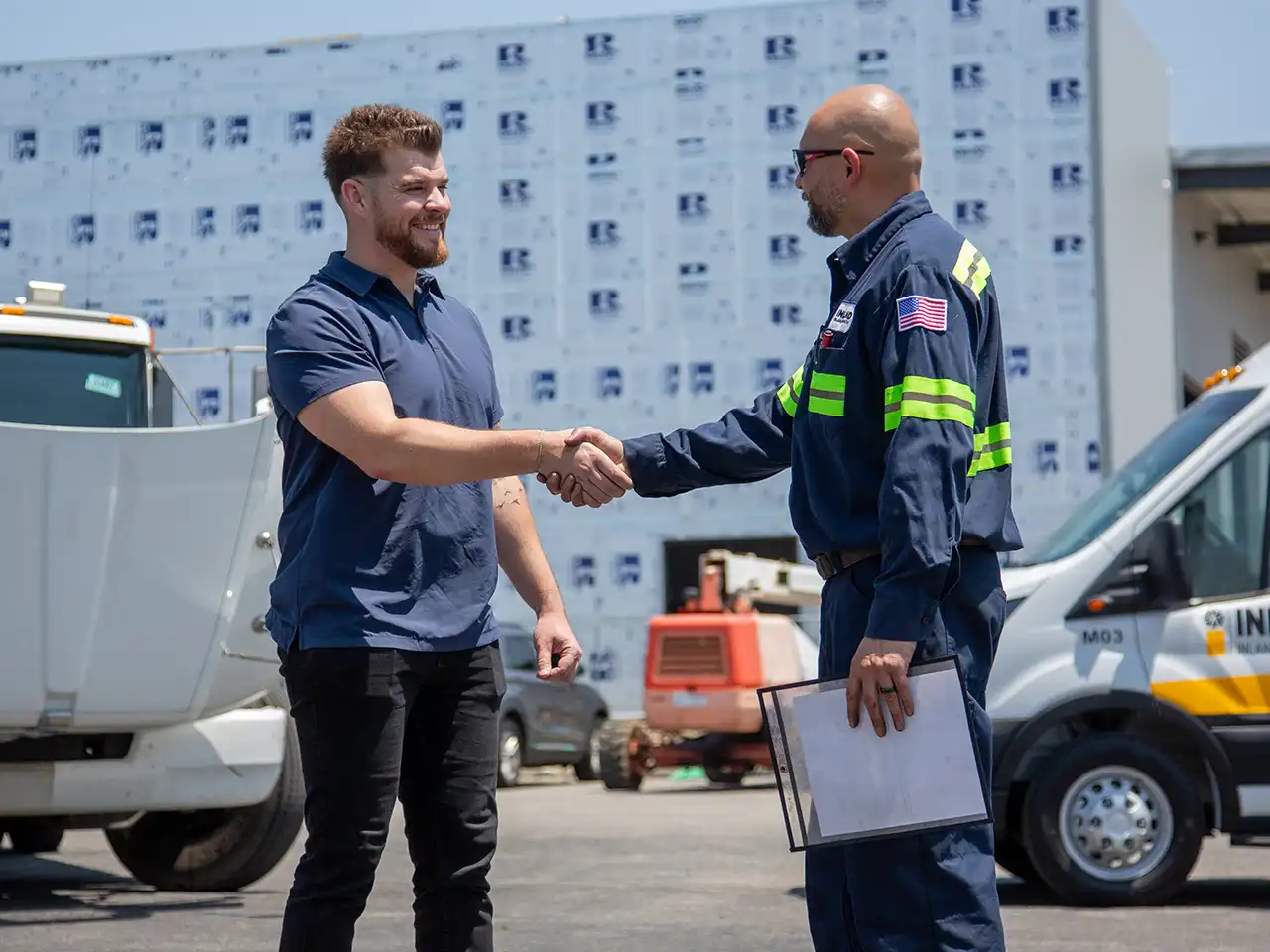 An Inland Kenworth mobile service technician greeting a customer who needs service on his semi-truck.